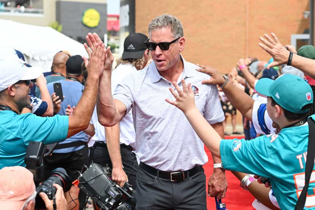 Hall of Fame quarterback Troy Aikman celebrates with fans as he is introduced prior to the 2023 Pro Football Hall of Fame Enshrinement Ceremony at Tom Benson Hall Of Fame Stadium on August 05, 2023 in Canton, Ohio.