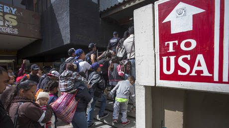 Members of a caravan of Central Americans who spent weeks traveling across Mexico walk from Mexico to the U.S. side of the border to ask authorities for asylum on April 29, 2018 in Tijuana, Baja California Norte, Mexico