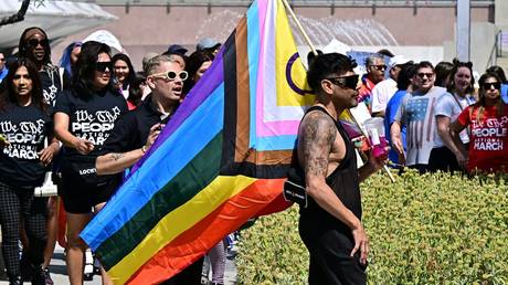 A demonstrator carries a flag during the We The People National March in Los Angeles, California, on July 2, 2023