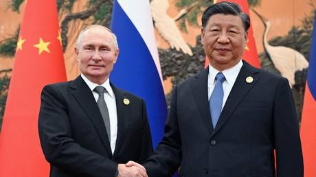 Russia's President Vladimir Putin and Chinese President Xi Jinping shaking hands during a meeting in Beijing on October 18, 2023.