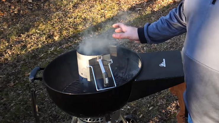 charcoal chimney started placed in the center of a kettle grill