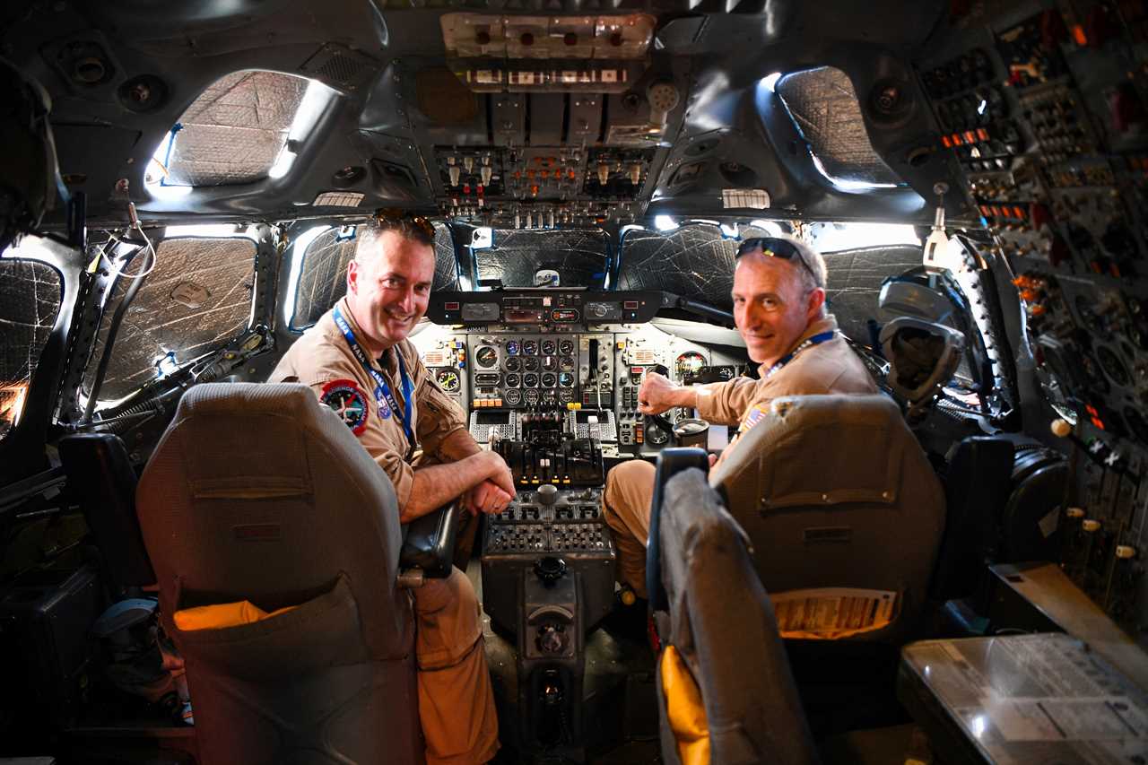 Andy Barry (L) and Greg Slover, pilots of the NASAs DC-8 airborne science laboratory, pose for a photo inside the cockpit of the aircraft