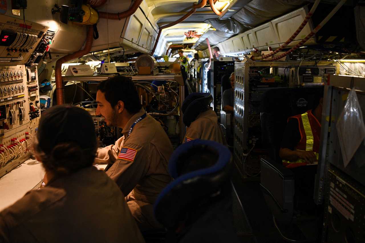 Crew and scientists of NASAs DC-8 airborne science laboratory work inside the aircraft