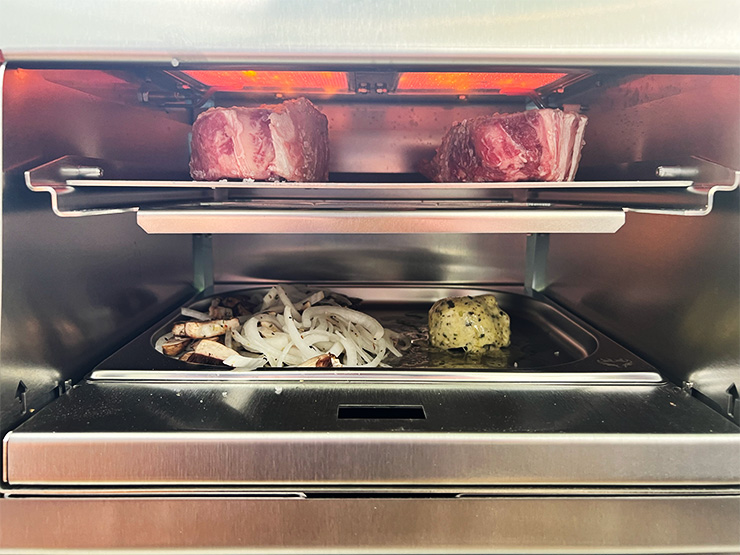 uncooked steaks, veggies and compound butter on Schwank Infrared Grill