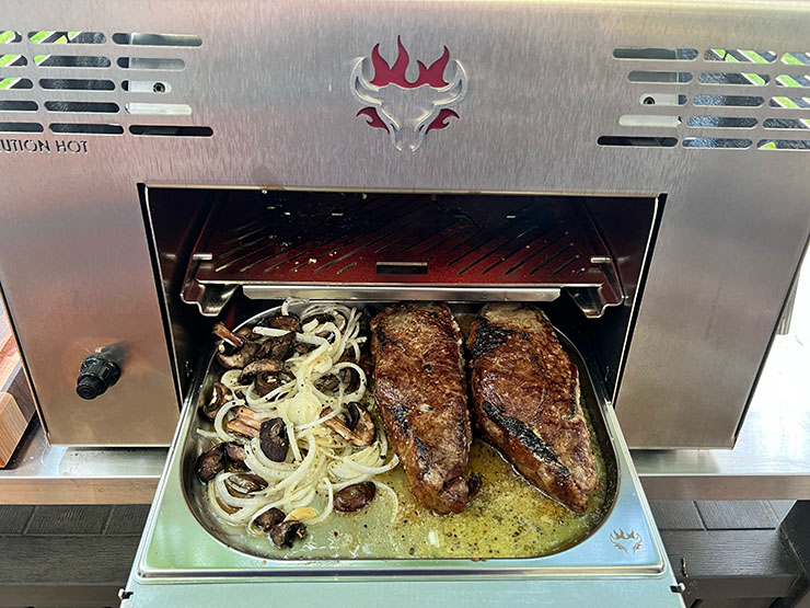 two grilled steaks and veggies on the Schwank Infrared Grill