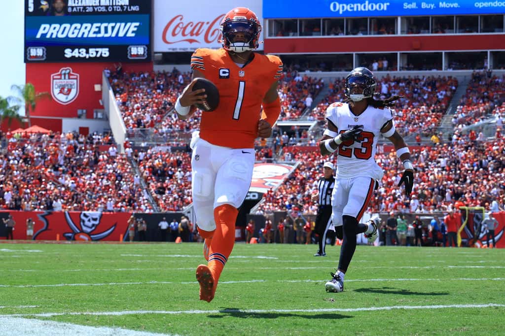 Justin Fields #1 of the Chicago Bears runs past Ryan Neal #23 of the Tampa Bay Buccaneers while scoring a touchdown during the first quarter at Raymond James Stadium on September 17, 2023 in Tampa, Florida.