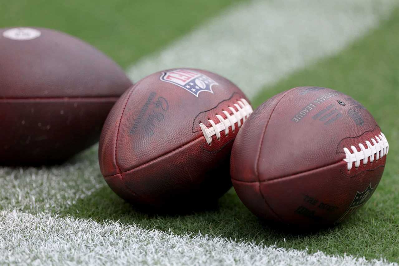 Footballs sit on the grass before the start of the Baltimore Ravens and Houston Texans game at M&T Bank Stadium on September 10, 2023 in Baltimore, Maryland.