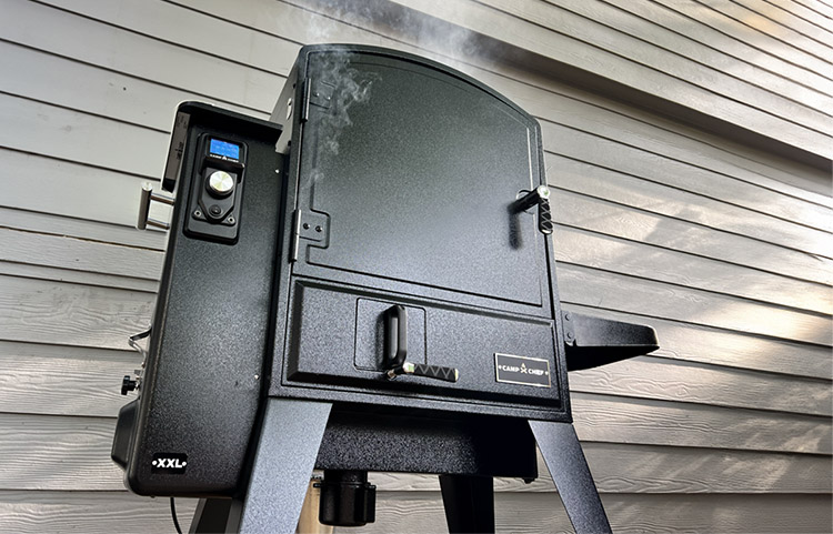 Camp Chef XXL Pro smoker standing next to house with smoke coming out