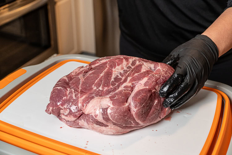 a raw piece of pork butt on a white board