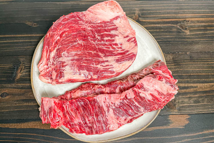 a piece of flank steak and skirt steak on a white plate