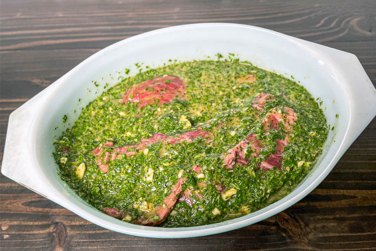 meat marinating in a white bowl