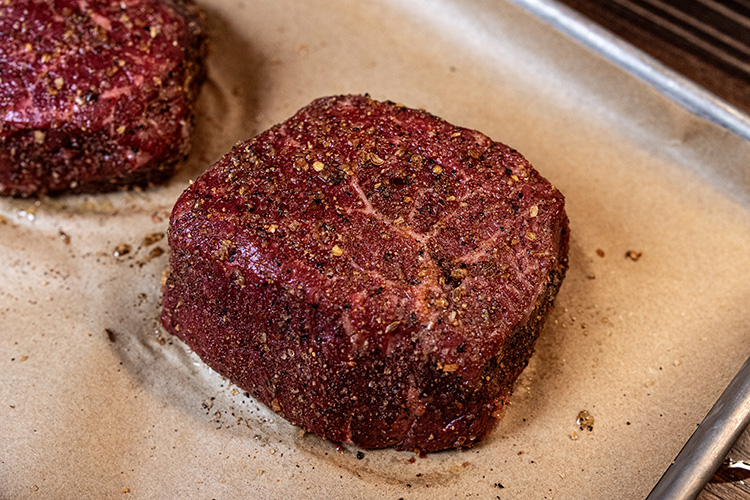 raw seasoned top sirloin steak on brown paper