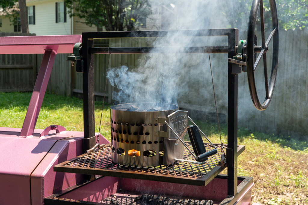 a chimney starter with smoke coming out sitting on a santa maria grill