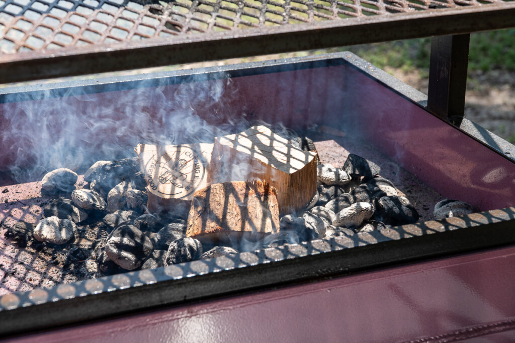 wood on top of hot coals on the grill