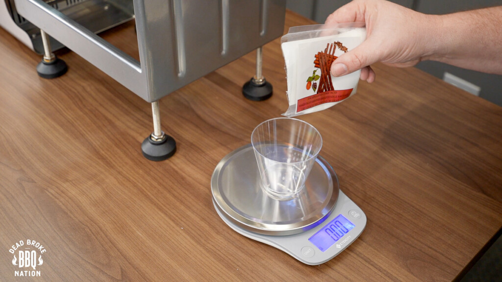 a set of scales with a plastic cup on top with powder being poured into it