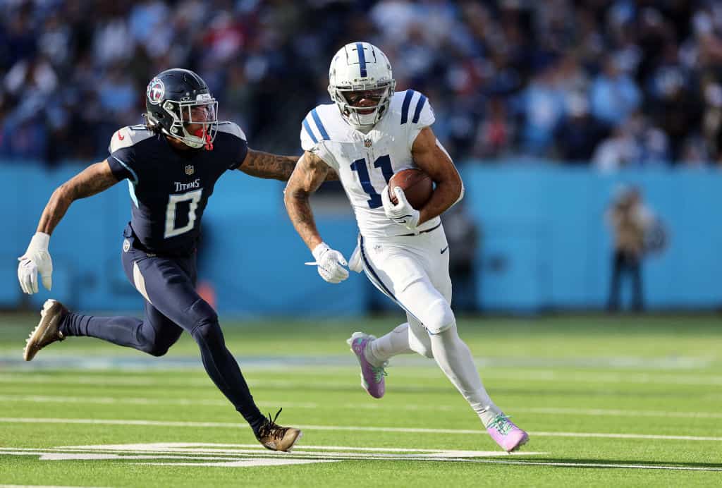 Michael Pittman Jr. #11 of the Indianapolis Colts carries the ball past Sean Murphy-Bunting #0 of the Tennessee Titans during the second half at Nissan Stadium on December 03, 2023 in Nashville, Tennessee.