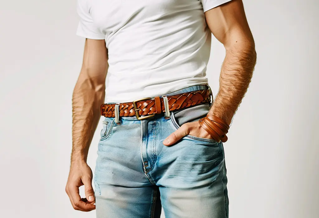 man wearing high-waisted, straight-fit jeans with a white tee shirt tastefully tucked in