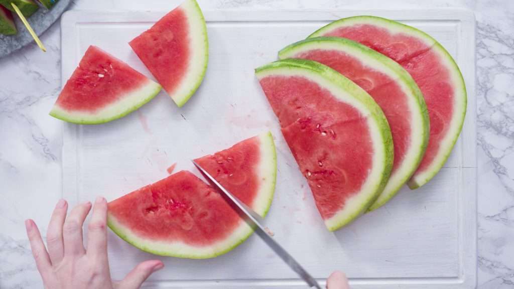 Seedless watermelon being sliced on a cutting board