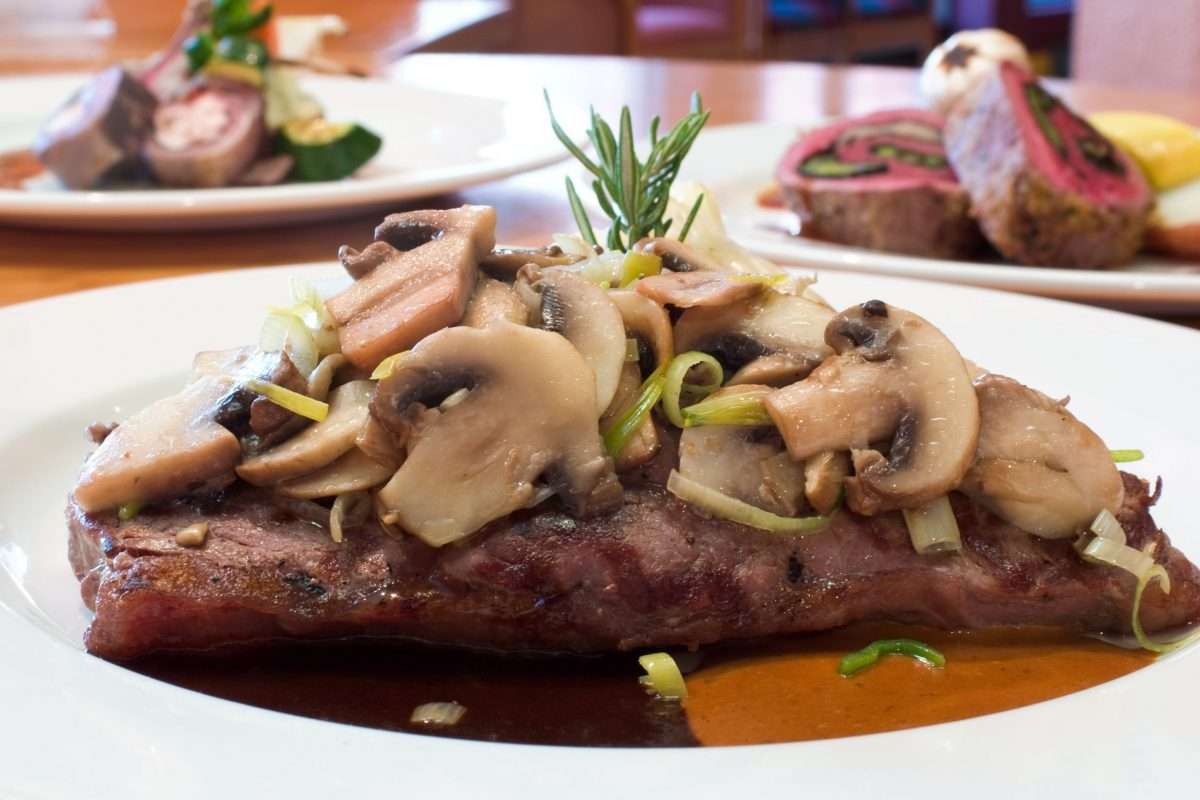 Delmonico Steak plated with mushrooms and sauce