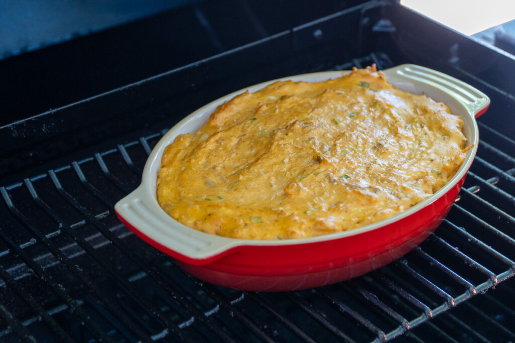 cooked smoked buffalo chicken dip in a red dish in the smoker