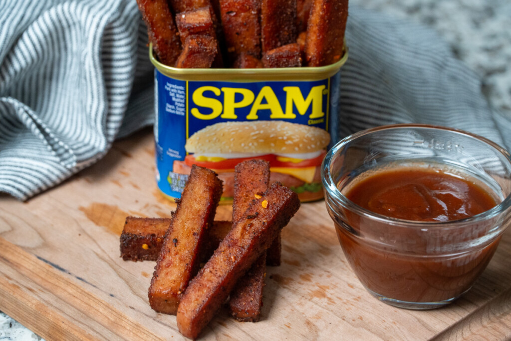 a tin of smoked spam fries, a pile of smoked spam fries and a bowl of bbq sauce