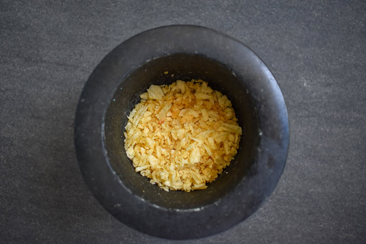 a black bowl with crushed potato chips