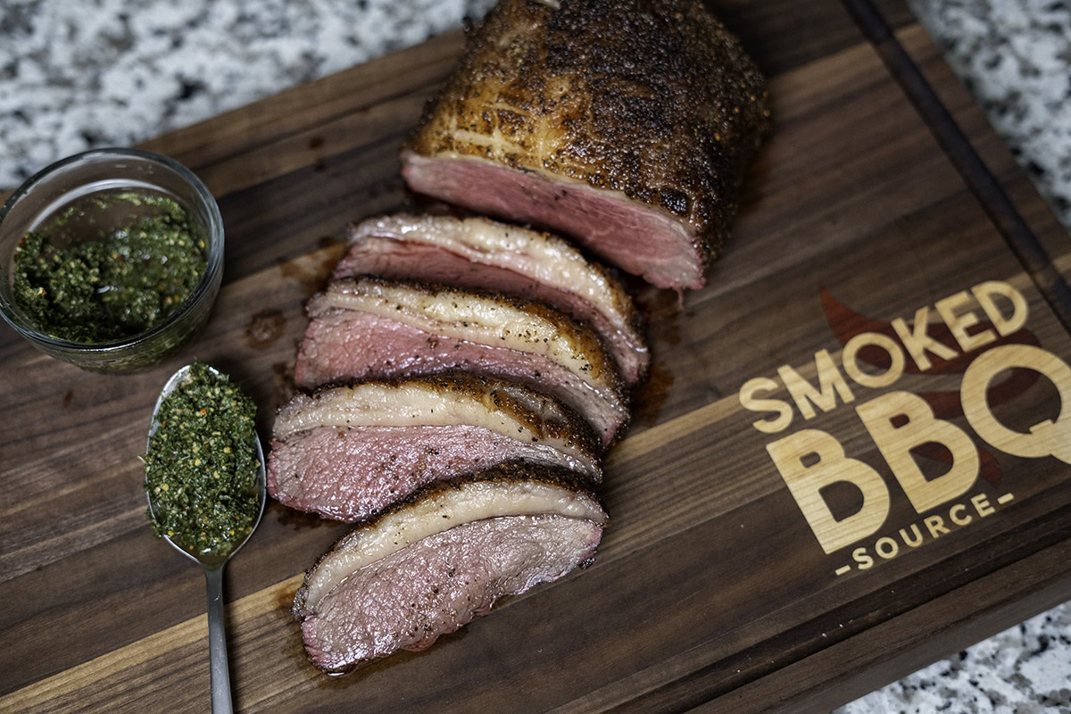 sliced picanha on custom butcher block with smoked bbq source logo