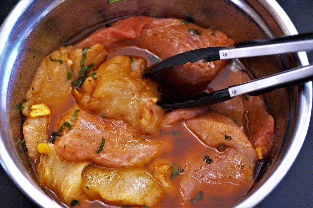 chicken marinating a bowl 