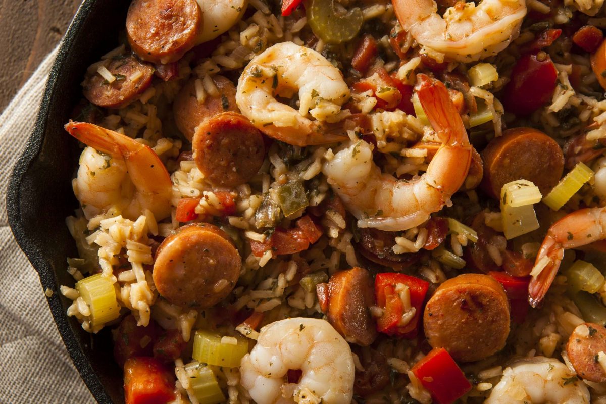 Jambalaya with sausage, shrimp, vegetables and spices in a cast-iron skillet