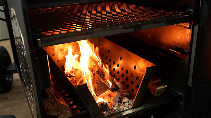 burning coals and wood splits inside the Lone Star Grillz offset smoker