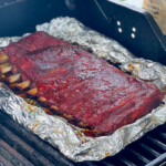 rack of ribs smoking on a gas grill