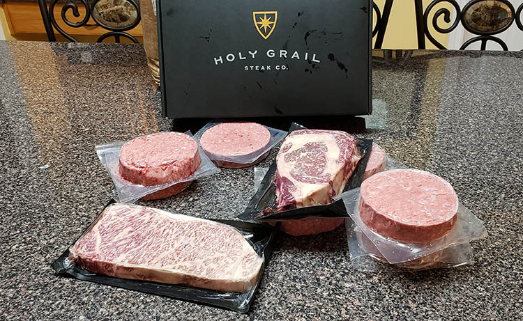 sealed meat cuts on a table with a box from an online meat order company