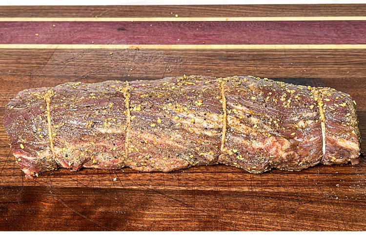 seasoned whole beef tenderloin on a wooden board