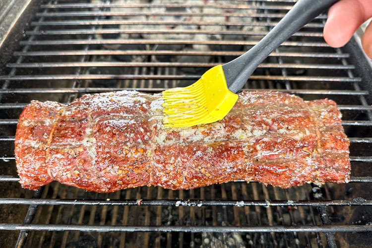 tenderloin being basted while on the grill