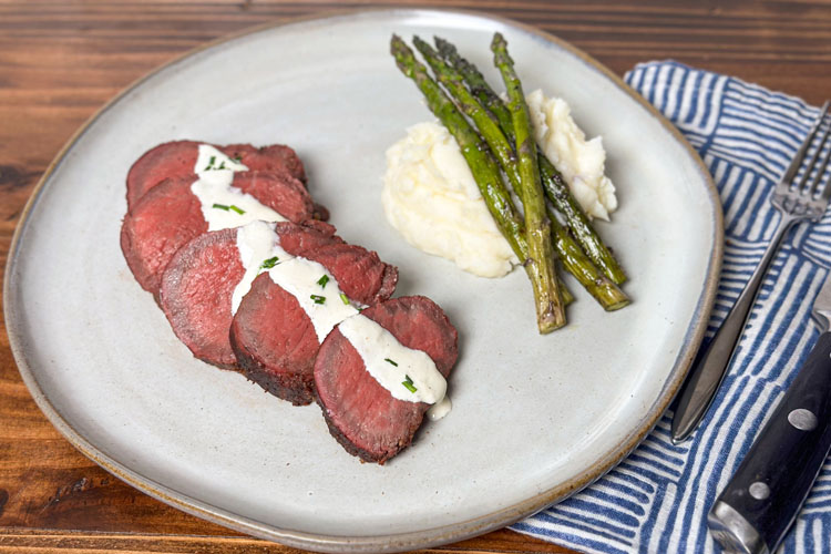 beef tenderloin plated with mashed potato and asparagus