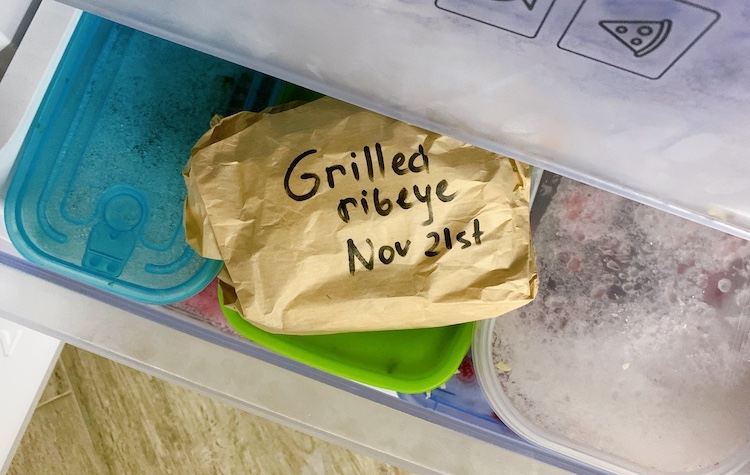 cooked steak wrapped in paper in a freezer