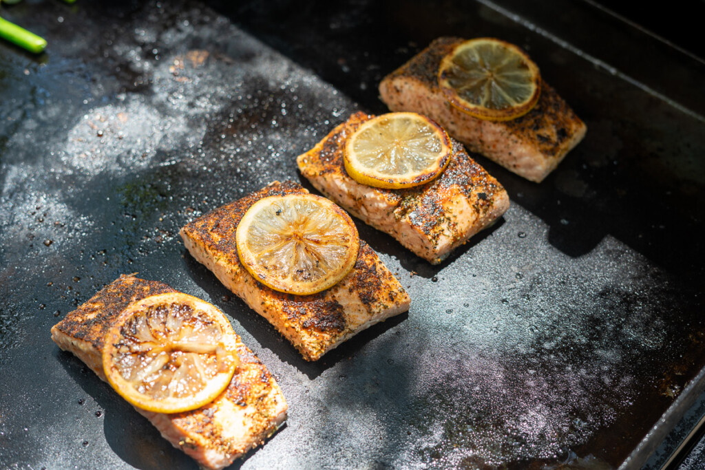 cooked salmon, with lemon slice on top on the griddle