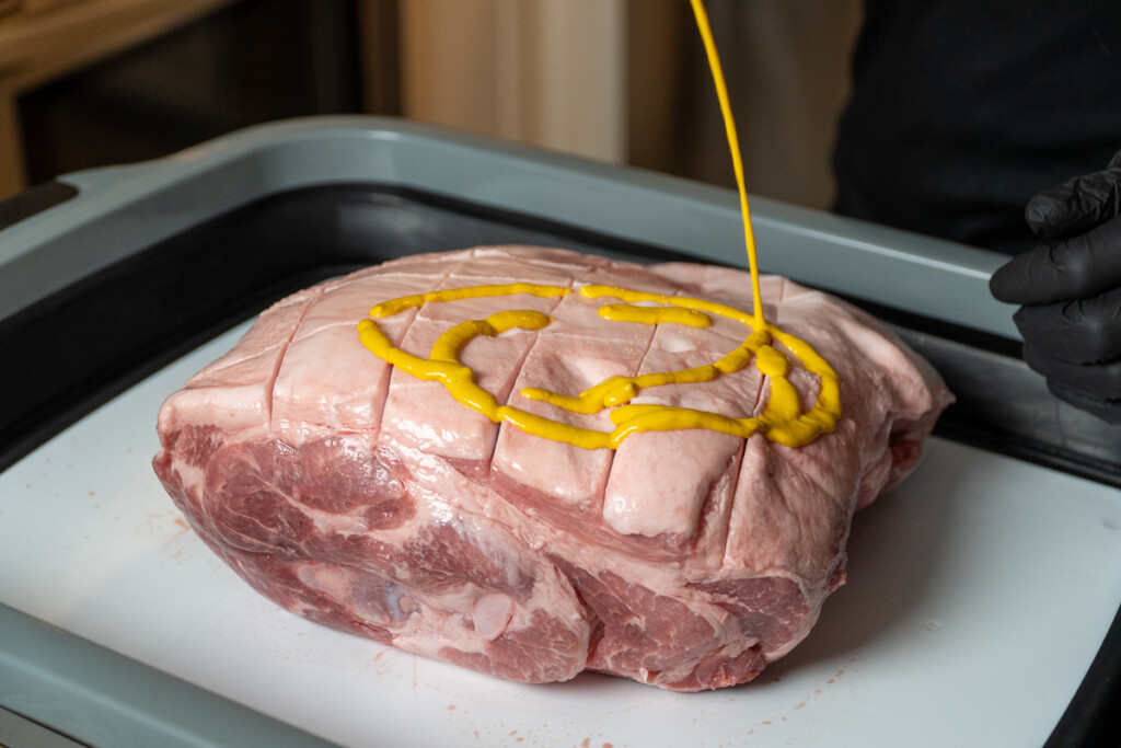 a squirt of mustard onto a raw pork butt