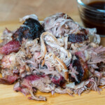 pellet grill pulled pork in a pile on a wooden board