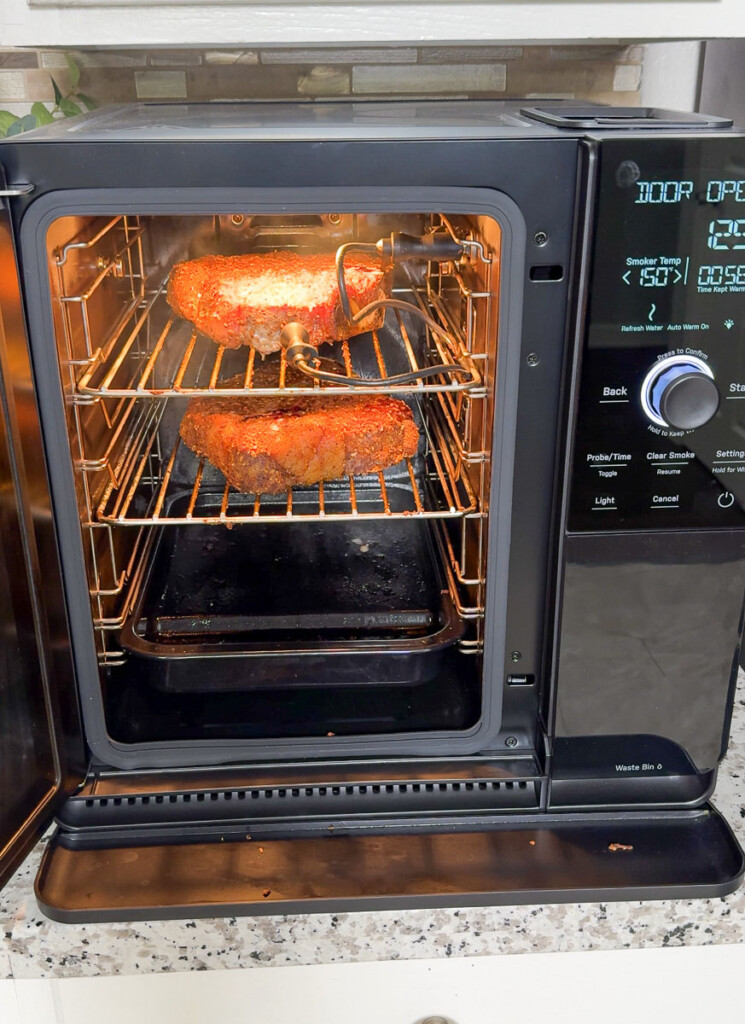 two porterhouse steaks smoking in the GE Profile indoor smoker