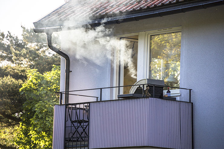 Smoke from a barbeque wafts up from an apartment balcony