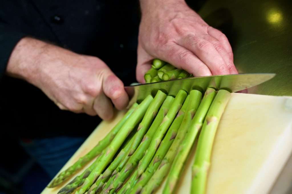 cutting off unusable pieces from asparagus