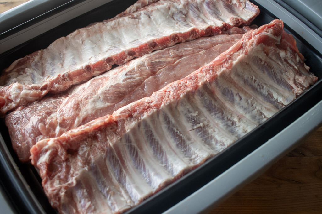 three racks of raw baby back ribs