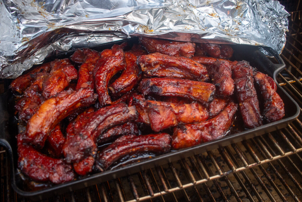 a tray of sauced party ribs in a tray