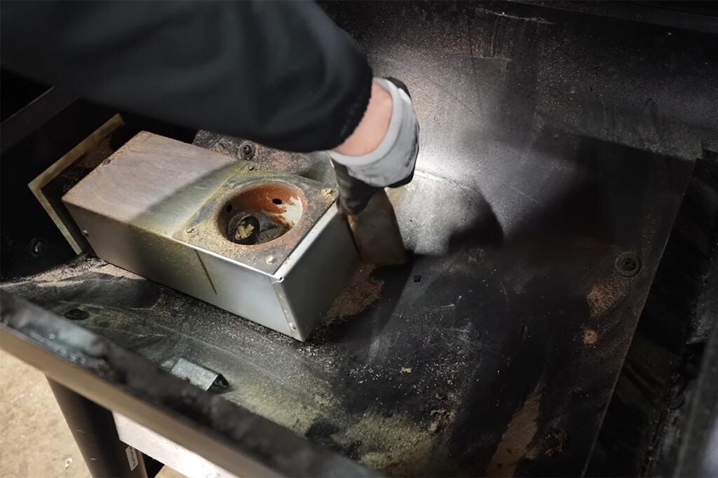 a person cleaning inside the Z Grills pellet grill with a vacuum