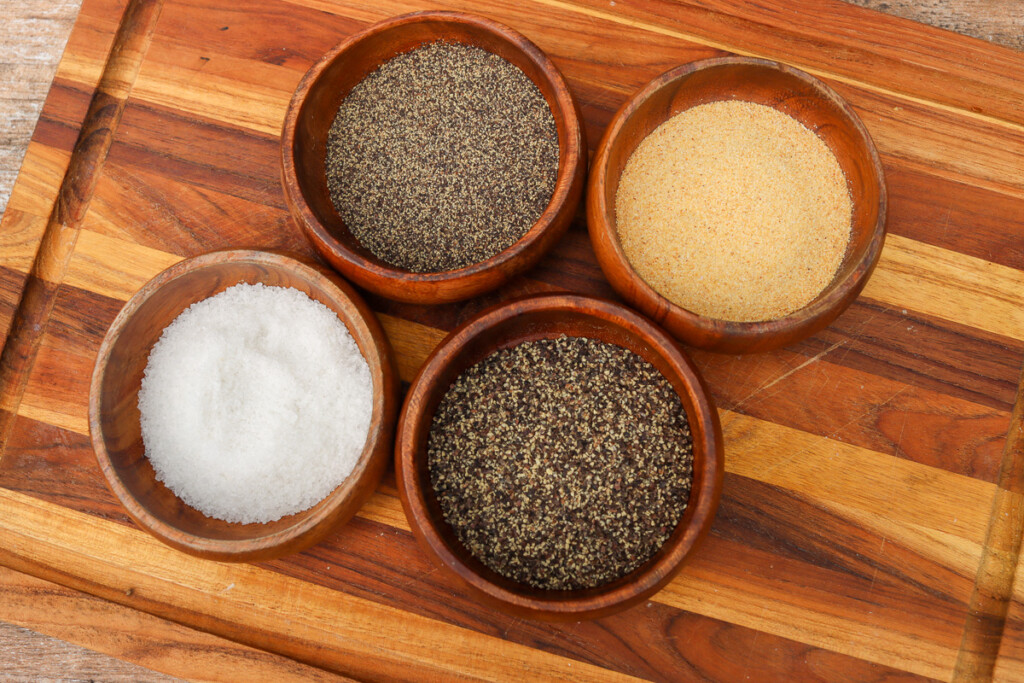 four bowls containing steak seasoning ingredients