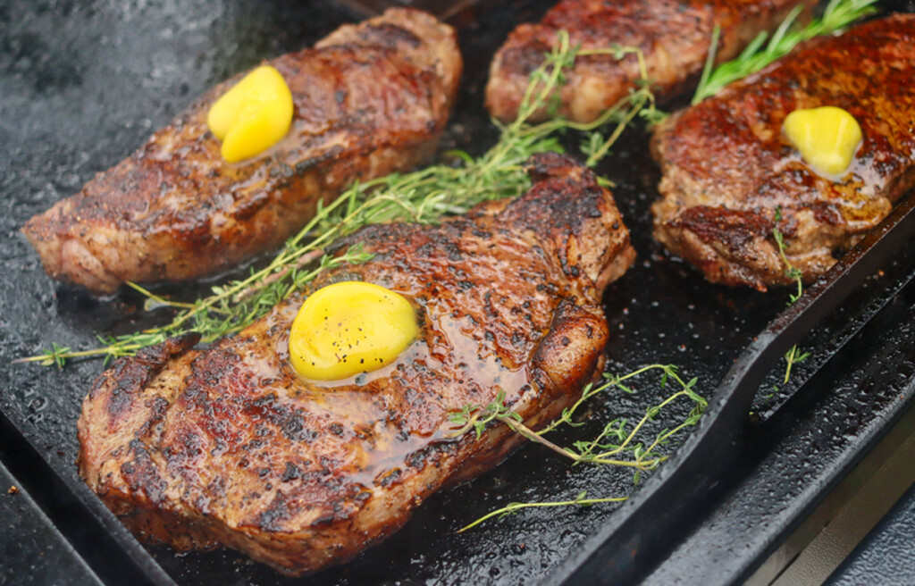 steak with ghee and herbs on the griddle