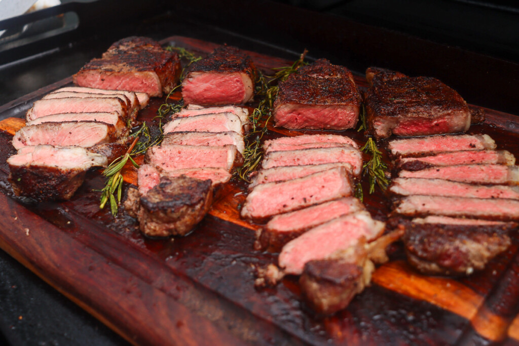 steaks sliced on a wooden chopping board