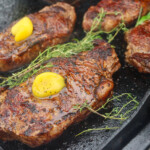 steak with ghee and herbs on the griddle