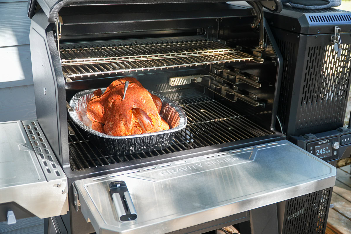 Smoked turkey in a foil tray inside the Masterbuilt Gravity XT grill